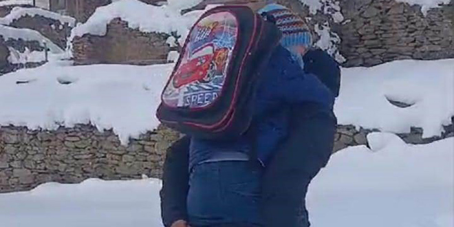 Karda yürüyemeyen öğrencisini evine kadar sırtında taşıdı